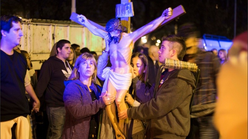 Fieles cargando la imagen de cristo en la cruz durante la ceremonia de las 14 estaciones.