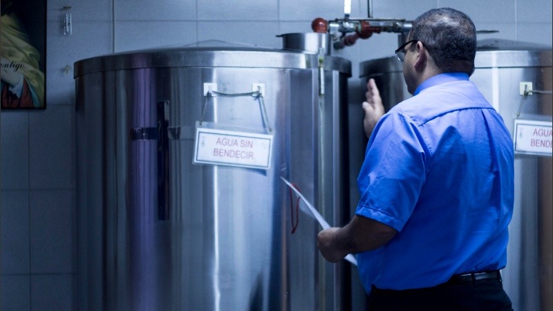 Un cura bendice los tanques donde se almacena el agua para los fieles