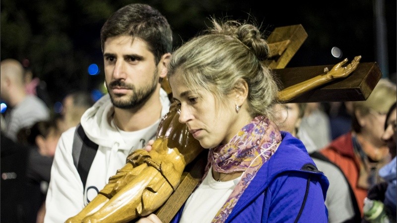 Los devotos se turnan para cargar el cristo crucificado durante el vía crucis