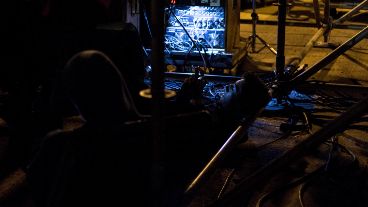 Un técnico aprovecha para tomarse un respiro mientras Ignacio se prepara para subir al púlpito