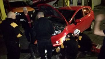 Los bomberos trabajando para sacar al gatito del motor