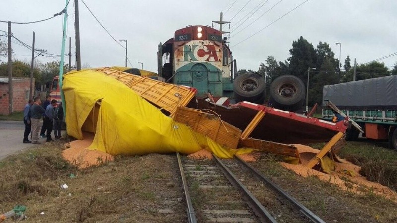 El camión destrozado y la carga sobre las vías.