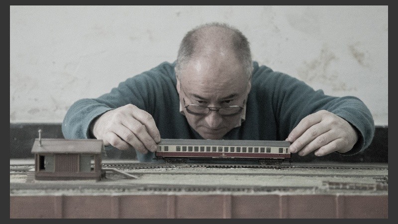 Carlos, uno de los asociados, pone sobre rieles uno de los diminutos vagones. (Alan Monzón/Rosario3.com)