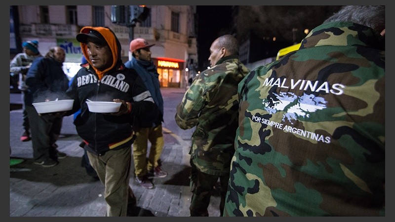 Integrantes del Centro de Ex combatientes de Malvinas ofrecen una ración de comida a los que más lo necesitan.