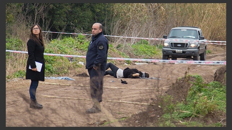 El cuerpo tendido en el camino de tierra.
