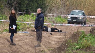 El cuerpo tendido en el camino de tierra.