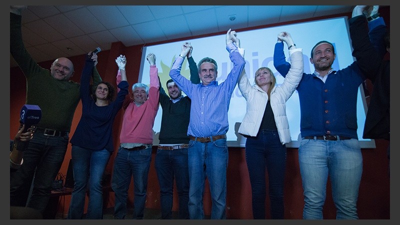 Rossi levanta los brazos junto a Iván Pérez, Norma López, Eduardo Seminara, M.de los Ángeles Sacnun y Roberto Sukerman.
