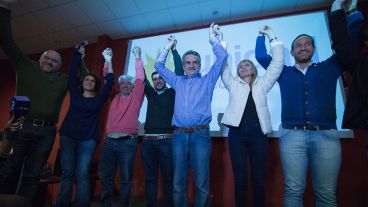 Rossi levanta los brazos junto a Iván Pérez, Norma López, Eduardo Seminara, M.de los Ángeles Sacnun y Roberto Sukerman.