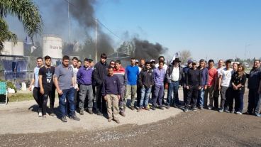 Los trabajadores despedidos este viernes en la puerta de la planta petrolera.