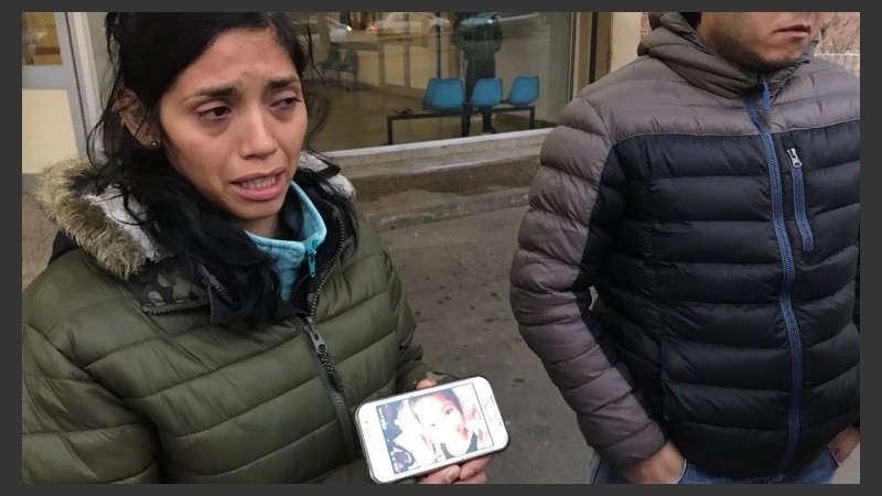 La desesperada madre muestra una foto de la nena. 