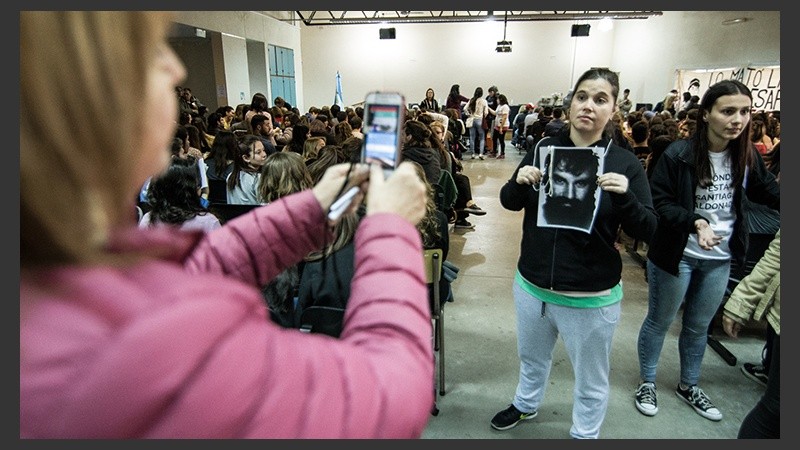 Una joven posa con un cartel. Muchos estudiantes se acercaron a la charla este martes. (Alan Monzón/Rosario3.com)