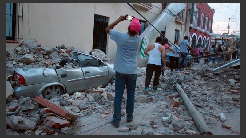 Personas caminan entre los escombros del poblado de Jojutla de Juárez.