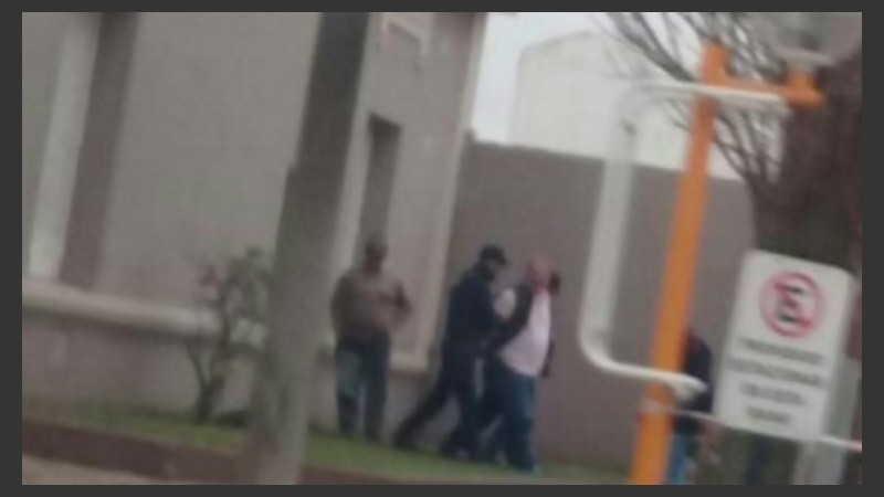 El momento en que los agentes de la PDI llevaban detenido a Coppari.