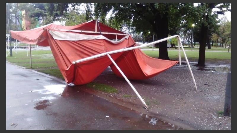 Un puesto de la feria en el parque caído por el viento.