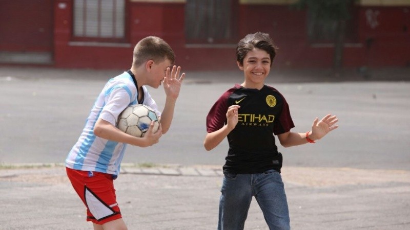 Dos chicos peleando contra la potencia del viento.