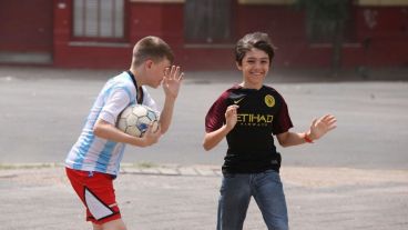 Dos chicos peleando contra la potencia del viento.