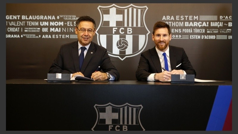 Messi, sonriente junto al presidente del Barsa Bartomeu. 