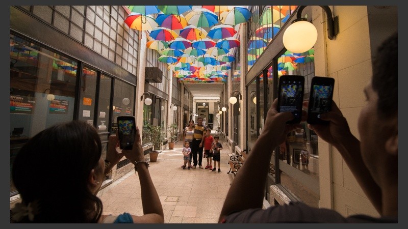 Rosarinos y turistas disfrutan de los paraguas de colores en el techo.