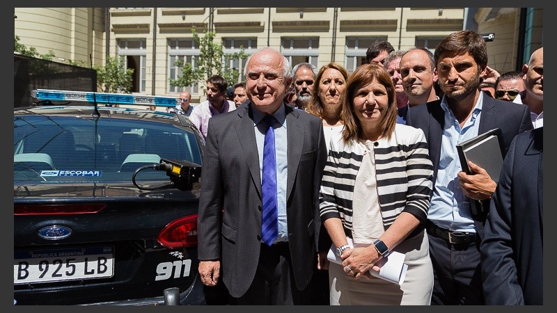 Los funcionarios posan al lado de los nuevos patrulleros inteligentes.