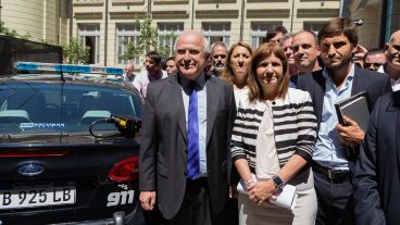 Los funcionarios posan al lado de los nuevos patrulleros inteligentes.