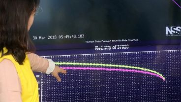 Una empleada observa un monitor con la posible trayectoria de caída del laboratorio espacial chino Tiangong-1.