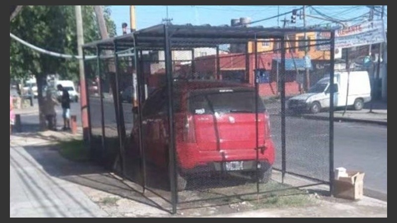 El auto en la jaula, una postal que sorprende en el barrio de Lanús