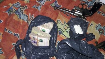 Dinero y armas secuestrados en el allanamiento.