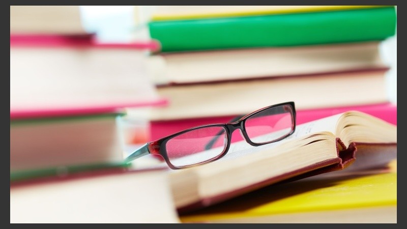 Close-up image of eyeglasses among piles of books