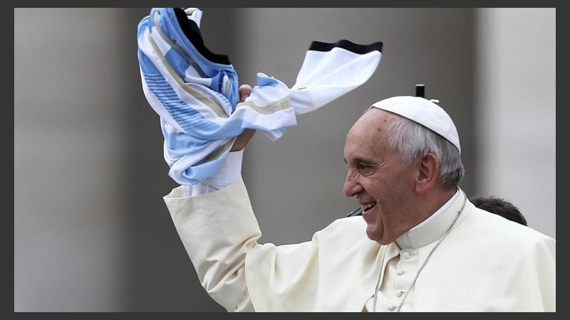 El Papa revolea una de las tantas camisetas que los fieles le obsequian.