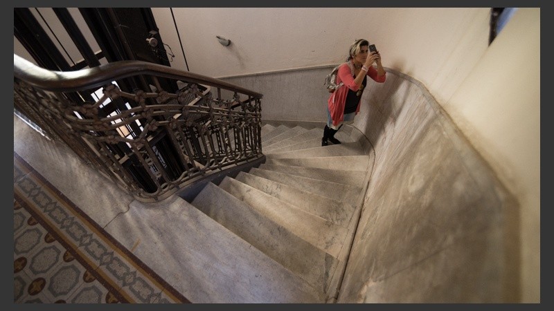 Una jóven toma una foto en uno de los edificios históricos de Rosario.