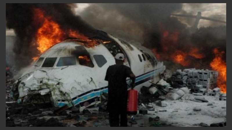 Bomberos tratando de extinguir el incendio tras la caída de la aeronave.
