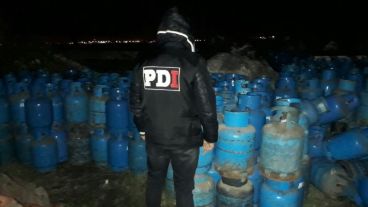 Un oficial de PDI con las garrafas robadas.