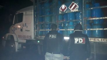 Oficiales de PDI con las garrafas secuestradas.