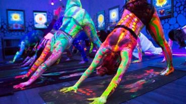 Yoguis iluminados con luces neón mientras practican