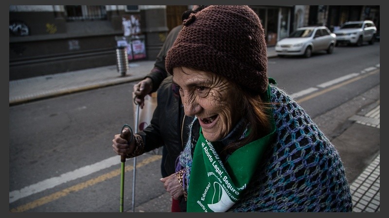 Una señora sonríe con su pañuelo verde esta mañana frente a Humanidades.