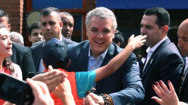 Duque saluda a simpatizantes al votar por la mañana.