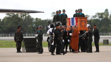 Un monje budista y varios miembros de la guardia de honor acompañan el féretro de Samam Kunan.