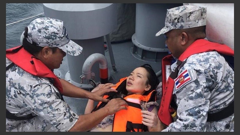 Efectivos de la Marina ayudan a una de las turistas rescatadas.