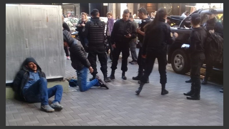 Los ladrones golpeados, a punto de ser llevados por la policía. 