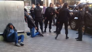 Los ladrones golpeados, a punto de ser llevados por la policía.