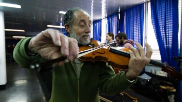 Un músico hace sonar uno de los violines de la exposición.