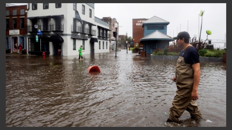 Varios vecinos caminan por calles inundadas tras el paso del huracán Florence.