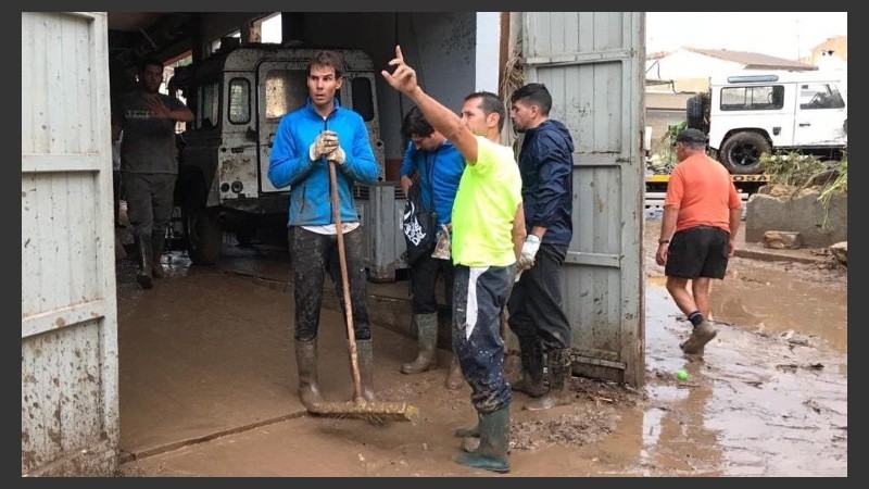 Rafa con las botas y la escoba en el barro de Mallorca. 