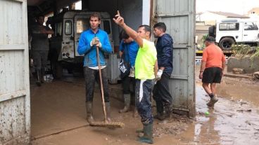 Rafa con las botas y la escoba en el barro de Mallorca.