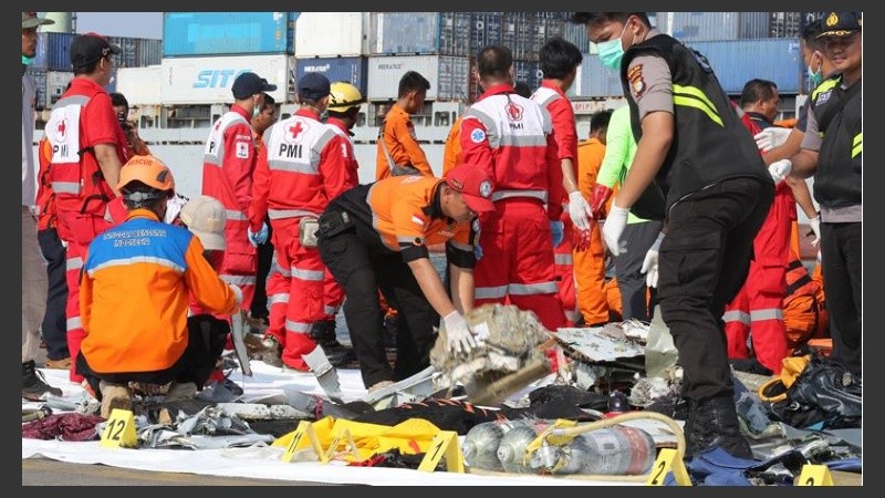 Miembros de los servicios de rescate trasladan los cuerpos.