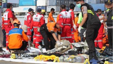 Miembros de los servicios de rescate trasladan los cuerpos.