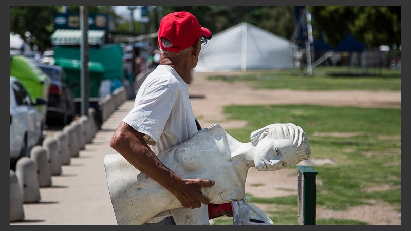Un hombre lleva un maniquí que se usará en uno de los stands de la Fiesta de Colectividades.
