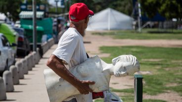 Un hombre lleva un maniquí que se usará en uno de los stands de la Fiesta de Colectividades.