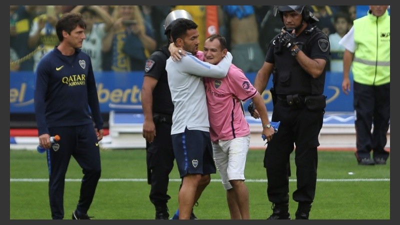 Un hincha saltó a la cancha y Tevez lo saludó.