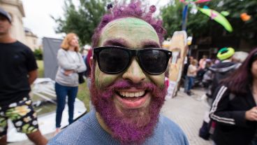 Un hombre con su rostro pintado sonríe para la cámara.